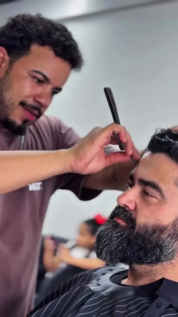 Barbeiro fazendo acabamento na navalha